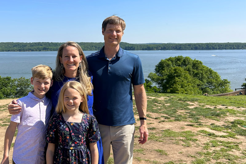 Higdon family standing outside in front of a beautiful waterway